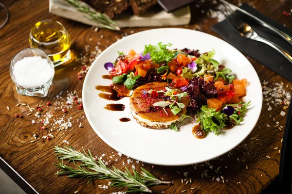 Salade de fromage de chèvre. Salade fraise-melon au piment, sauce pomme-orange, confiture de figue sur assiette blanche. Délicieux repas de viande servie sur une table pour le déjeuner dans un restaurant gastronomique de cuisine moderne — Photo