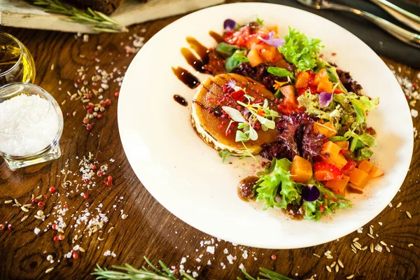 Salade de fromage de chèvre. Salade fraise-melon au piment, sauce pomme-orange, confiture de figue sur assiette blanche. Délicieux repas de viande servie sur une table pour le déjeuner dans un restaurant gastronomique de cuisine moderne — Photo