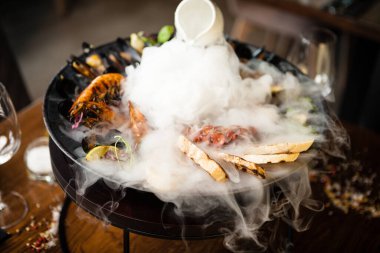 2-4 kişi için deniz ürünleri tabağı. Ahtapot, mavi midye, pişmiş yeşil midye, ızgara kaplan karidesi, ton balığı. Lezzetli deniz ürünleri modern gurme restoranında öğle yemeğinde servis edilir..