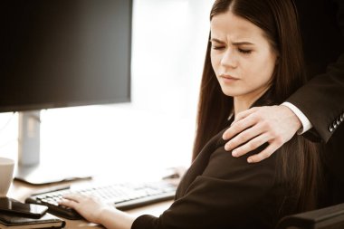 İş yerinde cinsel taciz. Erkek işadamı, iş yerinde uygunsuz davranışlar sergileyen rahatsız bir bayan asistanın omzuna elini koyar. Modern ofiste iki kişi arasında çatışma var..