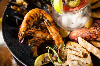 2-4 kişi için deniz ürünleri tabağı. Ahtapot, mavi midye, pişmiş yeşil midye, ızgara kaplan karidesi, ton balığı. Lezzetli deniz ürünleri modern gurme restoranında öğle yemeğinde servis edilir..