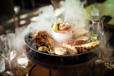 2-4 kişi için deniz ürünleri tabağı. Ahtapot, mavi midye, pişmiş yeşil midye, ızgara kaplan karidesi, ton balığı. Lezzetli deniz ürünleri modern gurme restoranında öğle yemeğinde servis edilir.