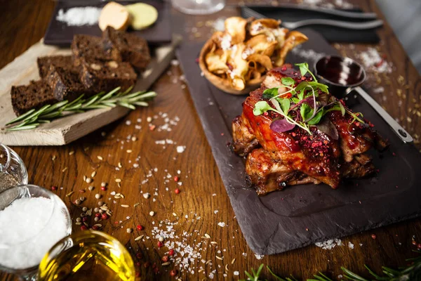 Costolette di maiale cotte a bassa temperatura. Salsa di ribes nero, patatine con parmigiano. Deliziosa carne sana primo piano servito su un tavolo per il pranzo in cucina moderna ristorante gourmet — Foto Stock