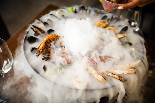 Seafood platter for 2-4 persons. Octopus, blue mussels, cooked green mussels, grilled tiger prawns, tuna tartare. Delicious seafood closeup served on a table for lunch in modern gourmet restaurant