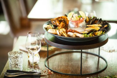 2-4 kişi için deniz ürünleri tabağı. Ahtapot, mavi midye, pişmiş yeşil midye, ızgara kaplan karidesi, ton balığı. Lezzetli deniz ürünleri modern gurme restoranında öğle yemeğinde servis edilir.