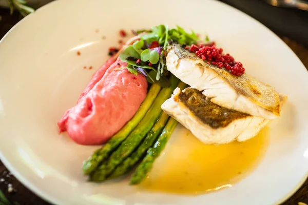 Pike-perch fillet. Asparagus, pearl couscous, white wine sauce, beet-flavored mashed potatoes. Delicious seafood fish closeup served on a table for lunch in modern cuisine gourmet restaurant — Stock Photo, Image