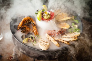 2-4 kişi için deniz ürünleri tabağı. Ahtapot, mavi midye, pişmiş yeşil midye, ızgara kaplan karidesi, ton balığı. Lezzetli deniz ürünleri modern gurme restoranında öğle yemeğinde servis edilir..