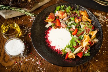 Kabuklu jambon salatası. Stracciatella ve Grana Padano peyniri, kurutulmuş domates, taze salatalık. Lezzetli, sağlıklı, karışık sebzeler yakın plan yemekler modern mutfak gurme restoranında öğle yemeği için servis edilir.