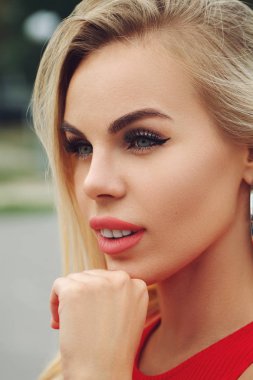 Güzel bir kadın yüzü ve yumuşak bir ruj. Seksi dolgun dudaklar. Kırmızı elbiseli kadın modelin dikey portresi. Yumuşak tenli kız yüzünün yakın çekimi. Kozmetik konsepti. Cilt bakımı kavramı