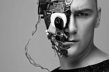 İnsan cyborgun tek renkli stüdyo fotoğrafı, yarı yüz bilgisayar elementleri ve profesyonel makyajlı, kafasında beyaz Iroquois. Gelecekteki teknoloji konsepti