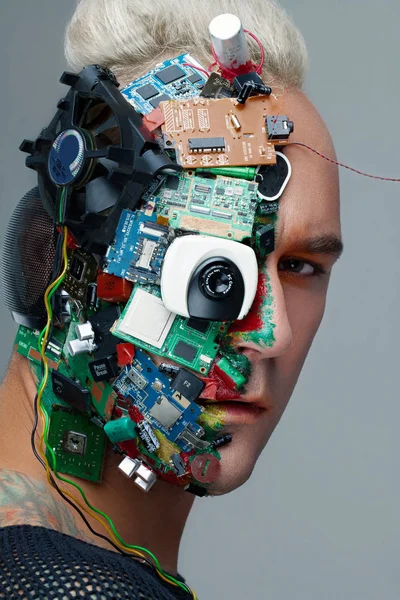 Studio fotoğraf adam cyborg, yarım yüz bilgisayar öğeleri ve profesyonel makyaj, beyaz Iroquois kafasına. Geleceğin teknolojisi kavramı