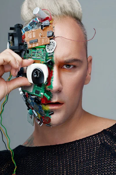 Studio fotoğraf adam cyborg, yarım yüz bilgisayar öğeleri ve profesyonel makyaj, beyaz Iroquois kafasına. Geleceğin teknolojisi kavramı