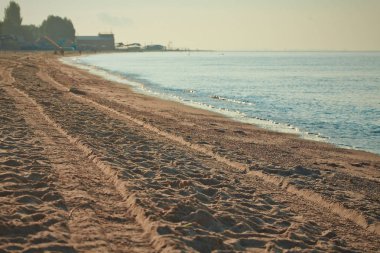 Bulanık plaj ve deniz dalgaları, vintage filtre arka plan. Sahilde yaz sıcak kum. Mavi gökyüzüile okyanus manzara. Güneşli bir gün ve güneş ışığı. Dekorasyon için boş alan.