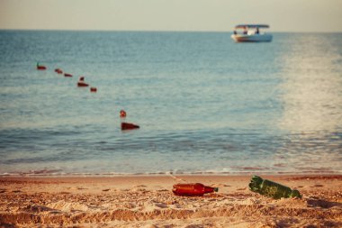 Sahilde yaz sıcak kum. Mavi gökyüzüile okyanus manzara. Denizde tekne. Bulanık plaj ve deniz dalgaları, vintage filtre arka plan. Güneşli bir gün ve güneş ışığı. Dekorasyon için boş alan.