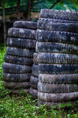 Paintball atış poligonu. Ormandaki paintball sahası. Ön planda çok renkli lekeler ve paintball silahından çıkan kurşunlardan kalan lekeler var. Bir arabanın ve ağaçların eski lastikleri.. 