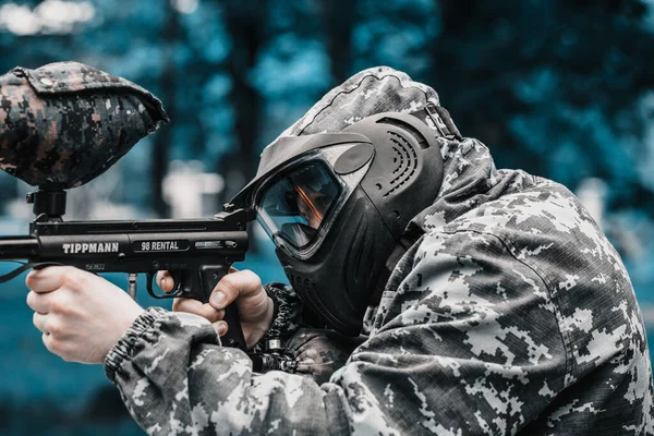 Paintball oyuncusunun Koruyucu Maske ve Kamuflaj Piksellerinde Paintball işaretiyle tam teçhizatlı portresi