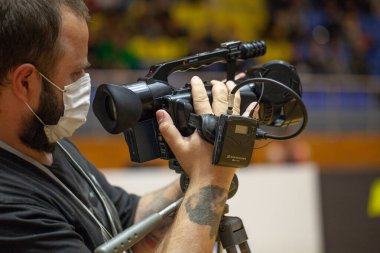 Kameranın önünde silahlı bir adam var.