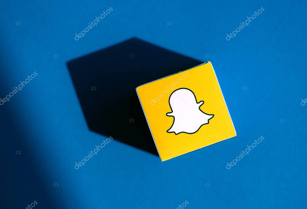 Kyiv, Ukraine - September 5, 2019: A shot from above of paper cube with the printed logotype of the Snapchat application, that placed on a blue background.