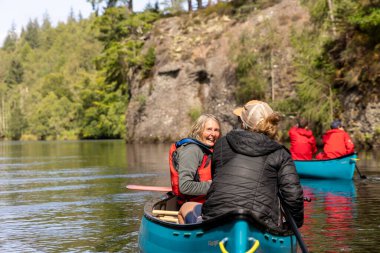 İskoçya, Birleşik Krallık, 4 Ağustos 2025: Bir grup insan bir nehirde kanolarda manzaranın ve birbirinin arkadaşlığının tadını çıkarıyorlar..