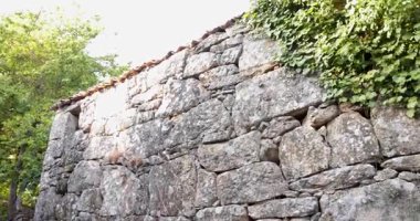 Üzerinde yosun büyüyen taş bir duvardaki pencere. Pencere küçük ve duvar çok eski.