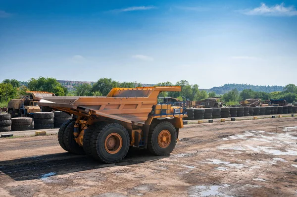 heavy yellow dump truck at repair station at sunny cloudless day