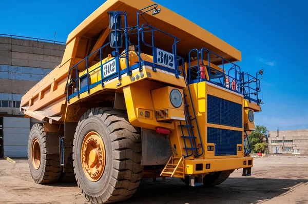 heavy yellow dump truck at repair station at sunny cloudless day