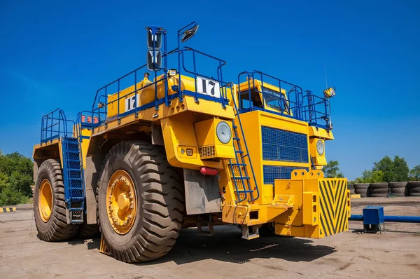 heavy yellow dump truck at repair station at sunny cloudless day