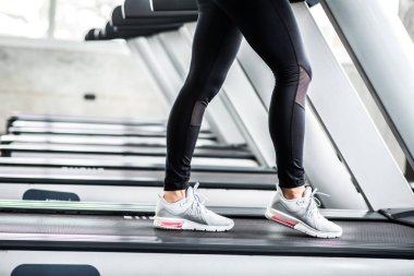 Spor salonunda koşu bandındaki Asyalı kadın.