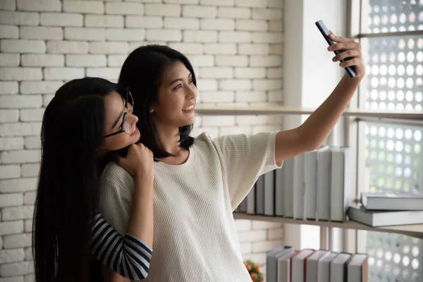 Two young Asian women selfie with mobile phones.Best friend relationship concept.