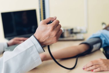 Doktorun kan basıncını ölçtüğü yakın plan, seçici odaklanma