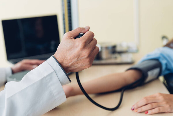 Close-up of doctor checking blood pressure, selective focus