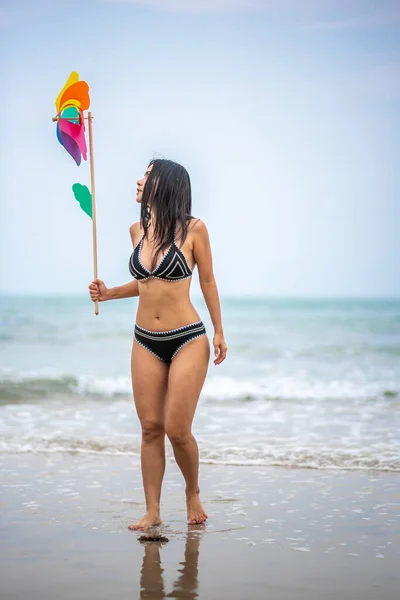 Vrouw Holding Pinwheel Speelgoed Tijdens Het Lopen Het Strand Tegen — Stockfoto