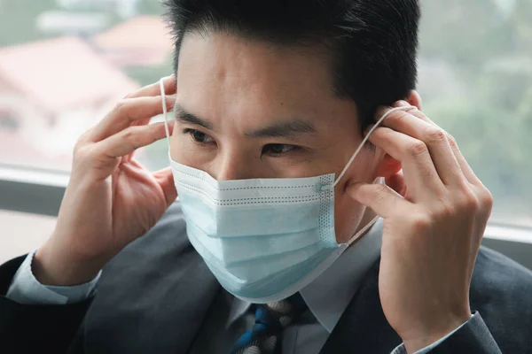 Close up asian businessman wearing face medical mask.