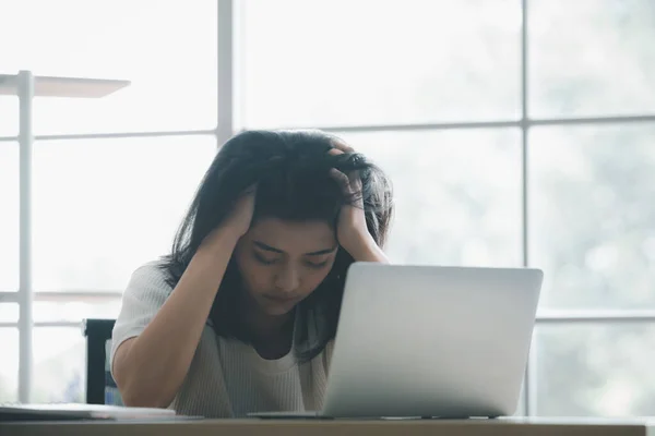 Stressed young asian woman using laptop, tired due to work