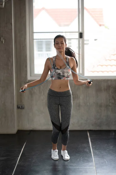 Young Woman Exercising With Jump Rope In Gym.