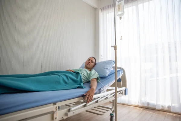 Young Man Lying On Bed At Hospital