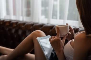 Genç Asyalı kadın evdeki kanepede dinleniyor..