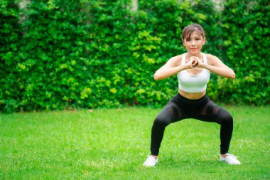 Genç Asyalı kadınlar koşmadan önce parkta ısınırlar..