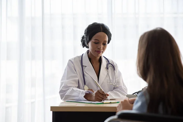 Doktor ve hasta hastanede otururken tartışıyorlar.