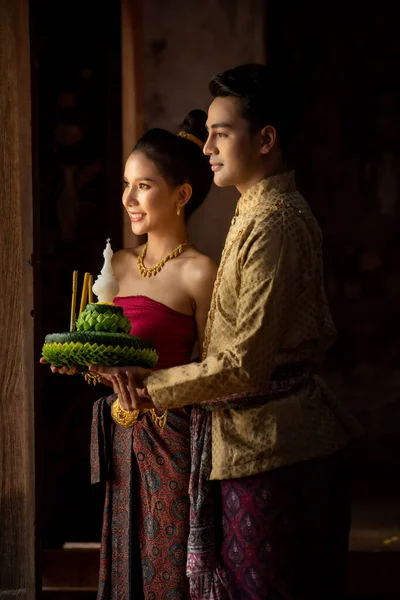 Geleneksel kostüm yapıp Krathong 'u dekore eden Taylandlı bir çift. Loy Krathong Festivali.