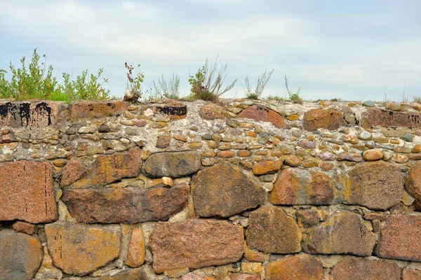 Old fortress wall made of granite blocks.