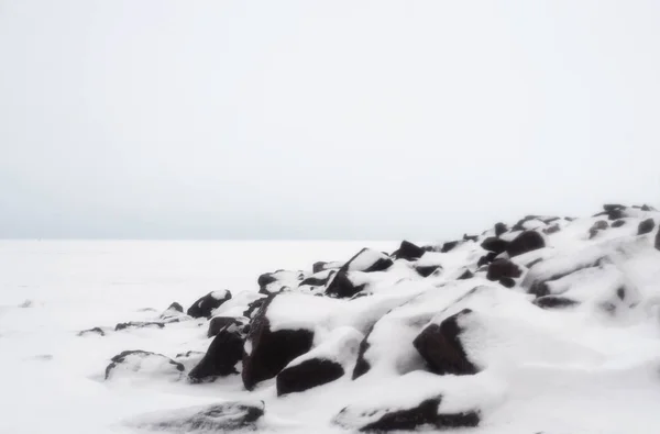 在云冬天在冻结的波罗的海海岸的花岗岩岩石 — 图库照片