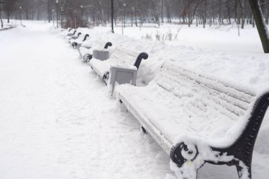 Bankların üzerinde bulut kış günü park sokak.