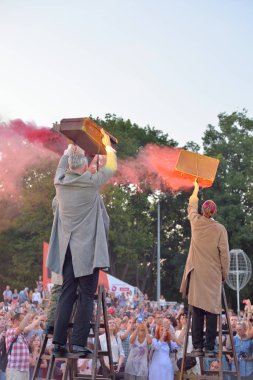 Sanatçılar sokakta tiyatro performansı oynuyor.