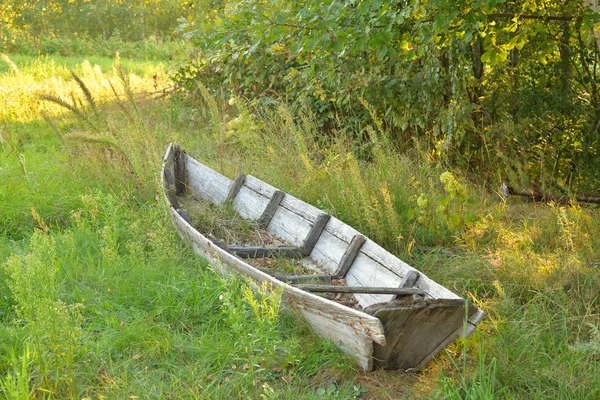 Oude gebroken boot op het gras. — Stockfoto