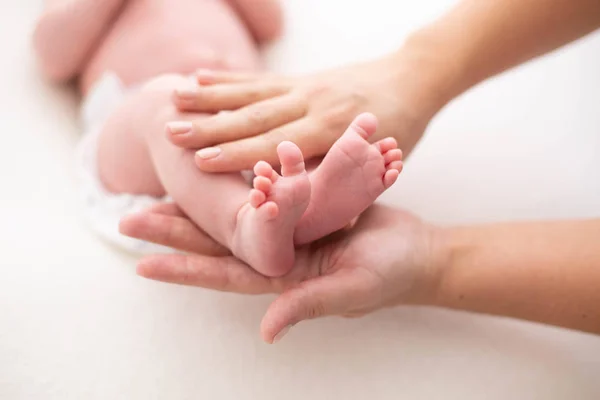 Babyfüße in die Hände der Mütter geschnallt. sanft verschwommener Hintergrund der Füße und Fersen eines Neugeborenen — Stockfoto