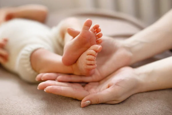 Babyfüße in die Hände der Mütter geschnallt. sanft verschwommener Hintergrund der Füße und Fersen eines Neugeborenen — Stockfoto