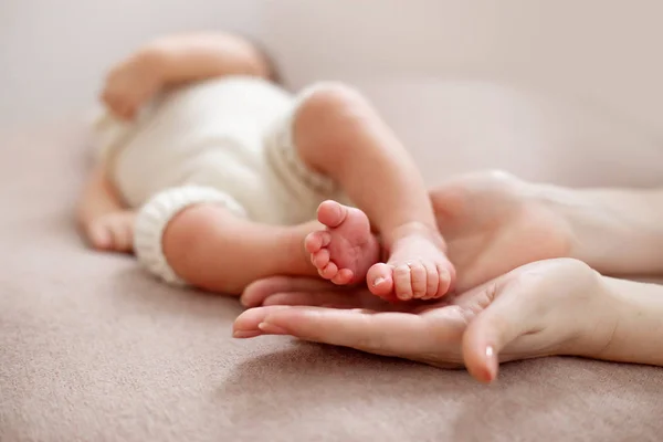 Babyfüße in die Hände der Mütter geschnallt. sanft verschwommener Hintergrund der Füße und Fersen eines Neugeborenen — Stockfoto