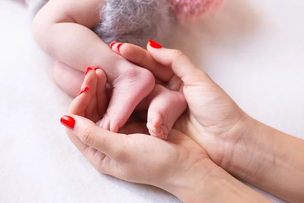 Babyfüße in die Hände der Mütter geschnallt. sanft verschwommener Hintergrund der Füße und Fersen eines Neugeborenen — Stockfoto