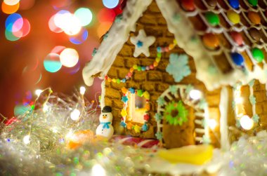 Işıkları ve kardan adamı olan zencefilli ekmek evi.